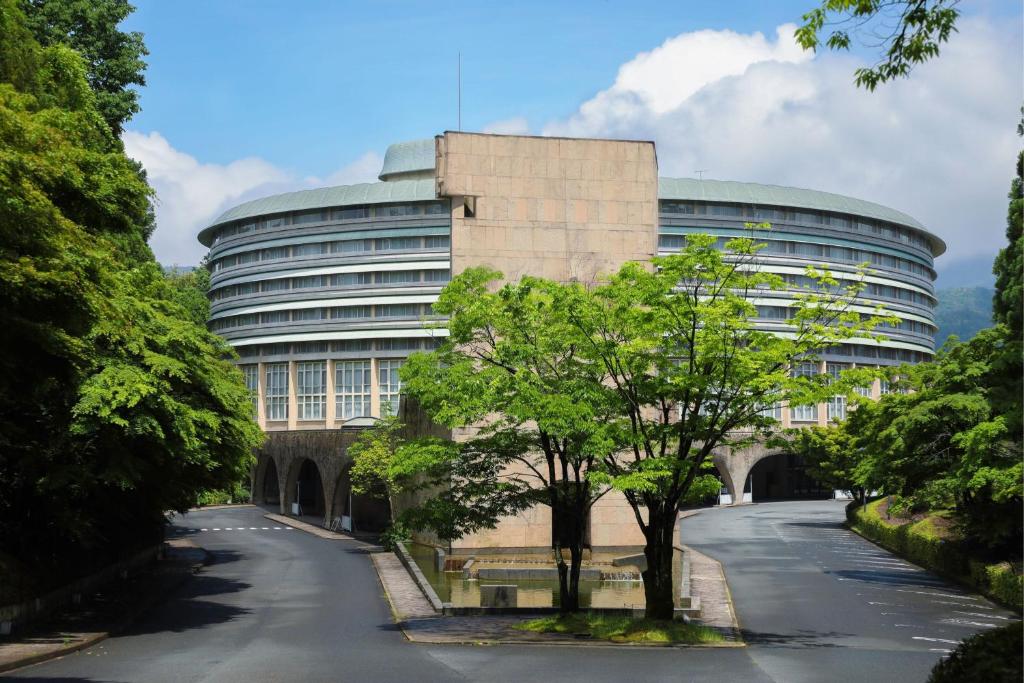 un immeuble de bureaux avec un arbre devant lui dans l'établissement The Prince Kyoto Takaragaike, Autograph Collection, à Kyoto