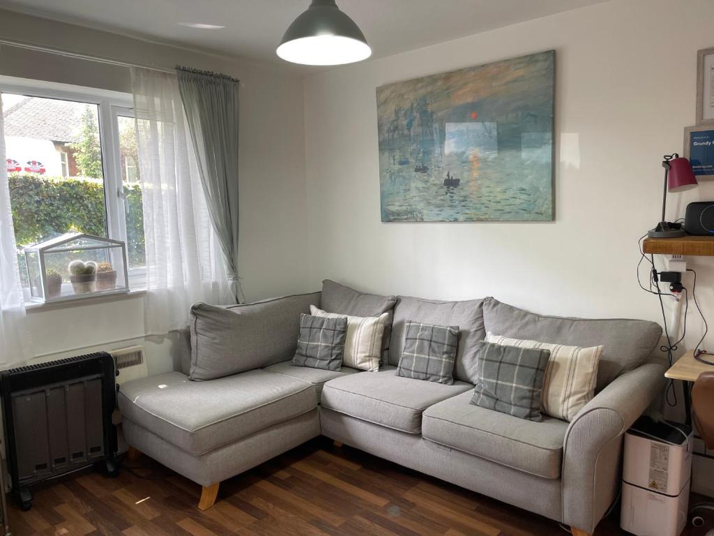 a living room with a couch and a window at Grundy House in Uxbridge