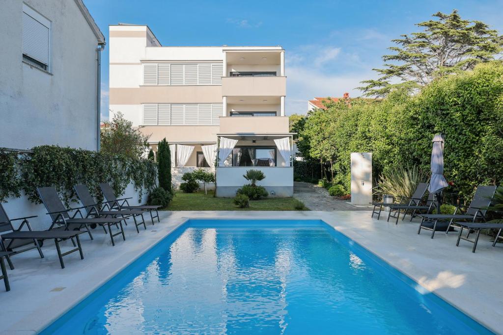 a swimming pool in front of a building at Apartments Mato in Zadar