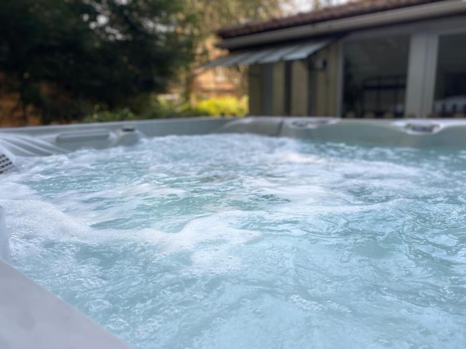 a hot tub filled with lots of blue water at Maison avec jardin et jacuzzi proche Polytechnique in Palaiseau