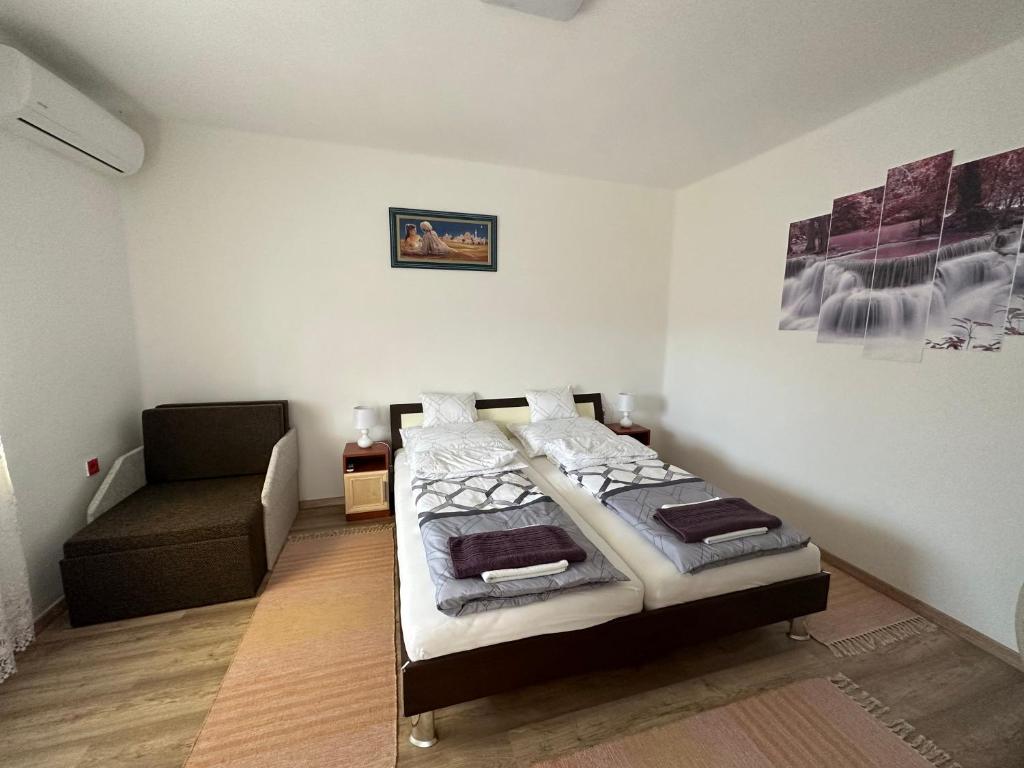 1 dormitorio con 1 cama y 1 silla en Fortuna Vendégház, en Egerszalók