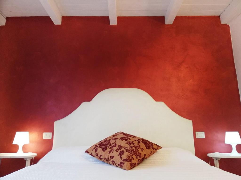 CereaにあるLocanda Divinisの赤い壁のベッドルーム1室(白いベッド1台付)