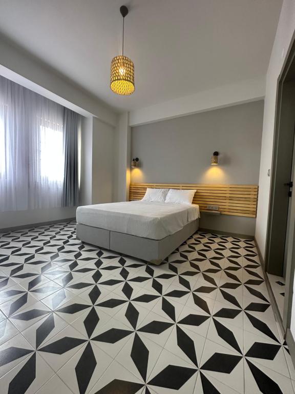 a bedroom with a bed and a black and white tiled floor at Arcadia Butik Otel in Canakkale