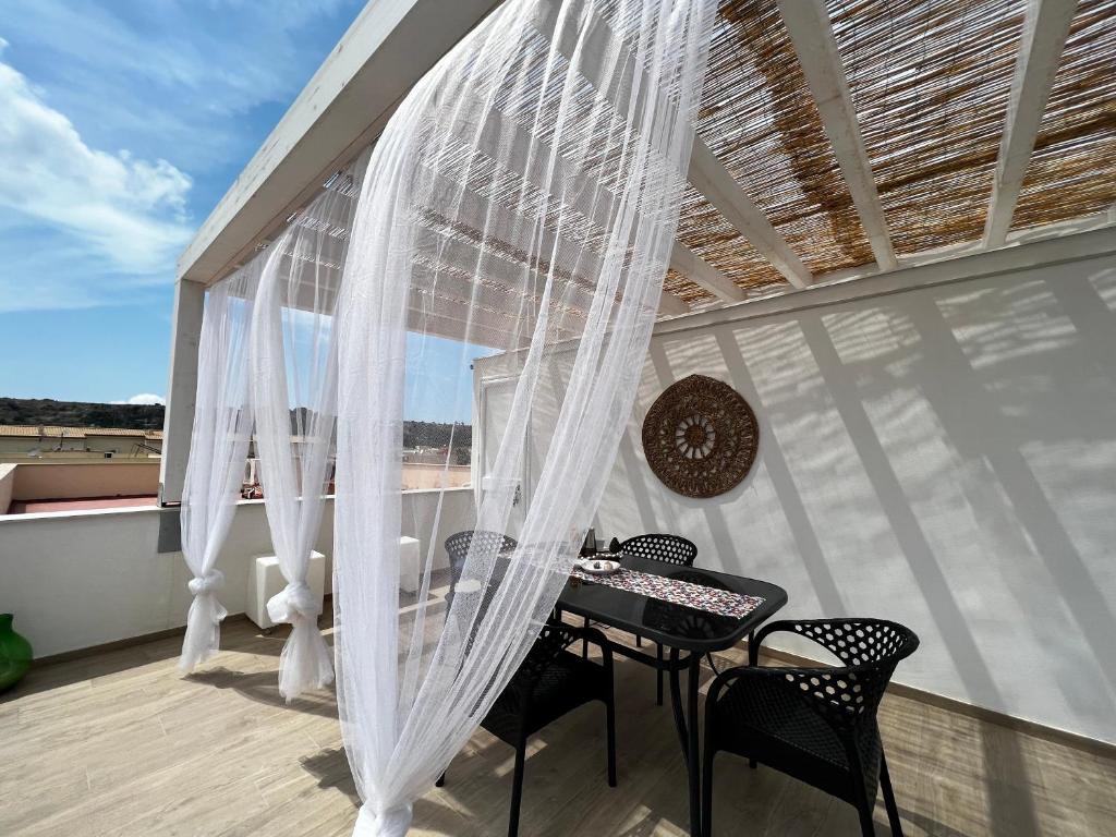 サン・ヴィート・ロ・カーポにあるsicily home casa vacanze con piscinaの窓付きのバルコニー(テーブル、椅子付)