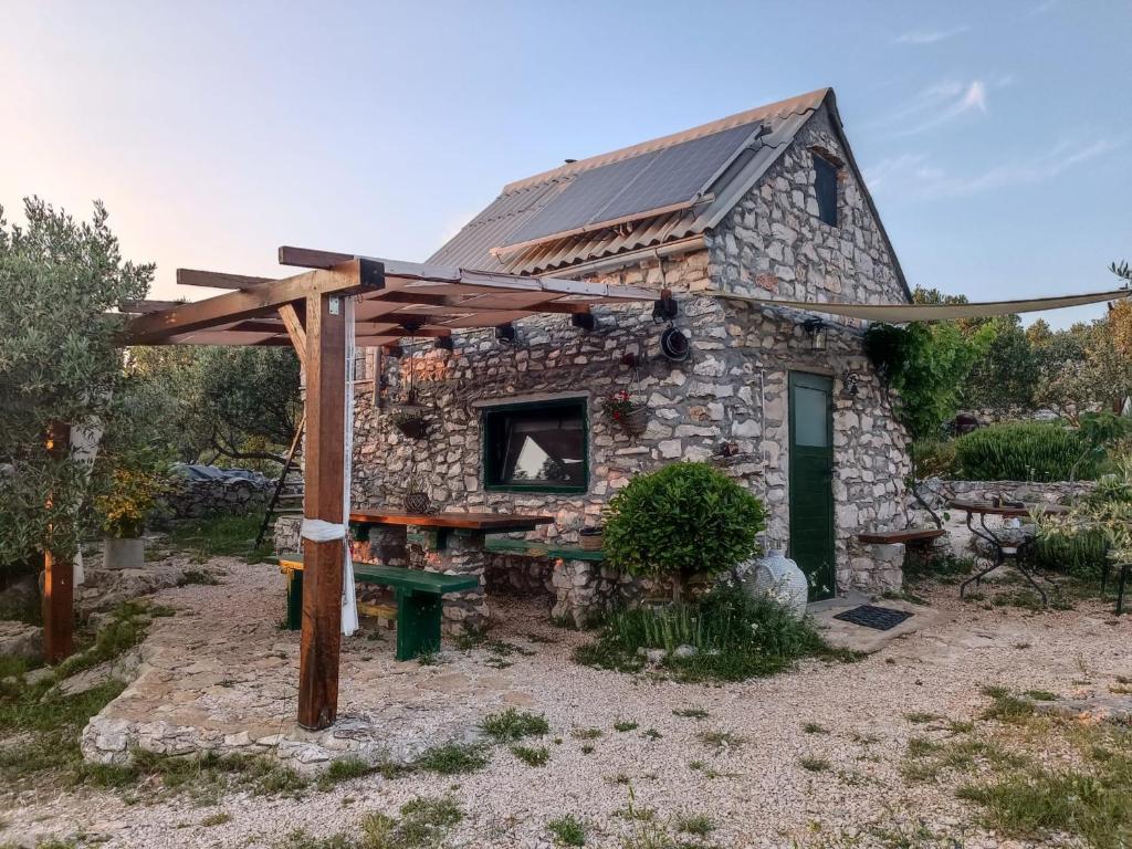 une maison en pierre avec une table de pique-nique devant elle dans l'établissement Mrdina house, à Kali