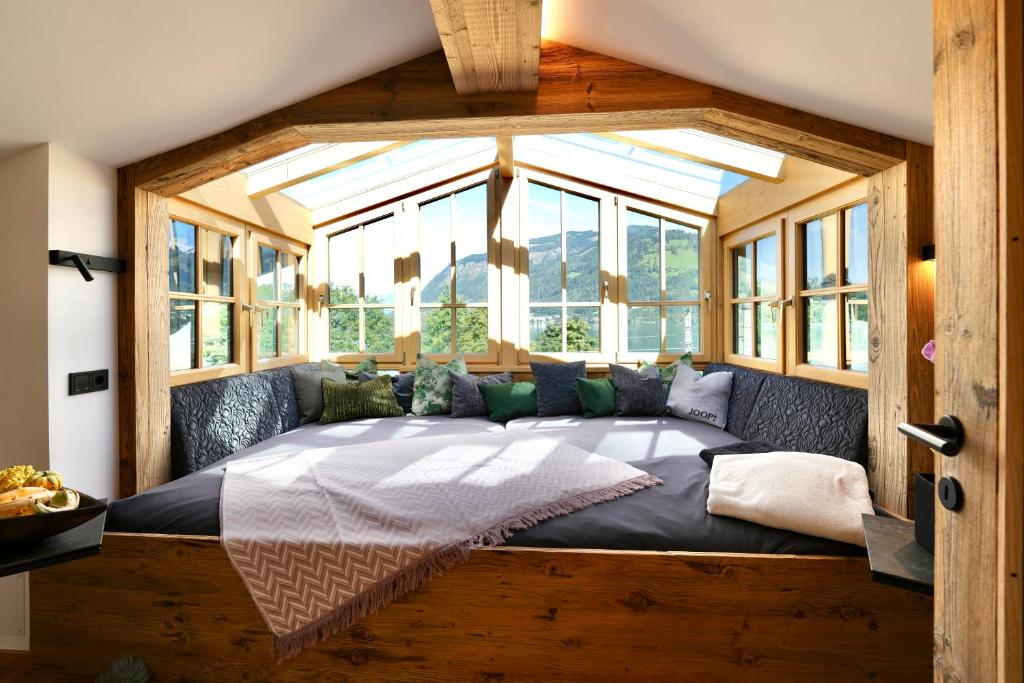 uma cama grande num quarto com uma janela grande em Lakeside Penthouse 16 by we rent em Zell am See