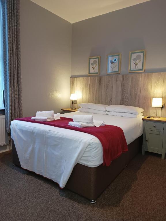 um quarto com uma cama grande e um cobertor vermelho em Westgate Hotel em Oxford