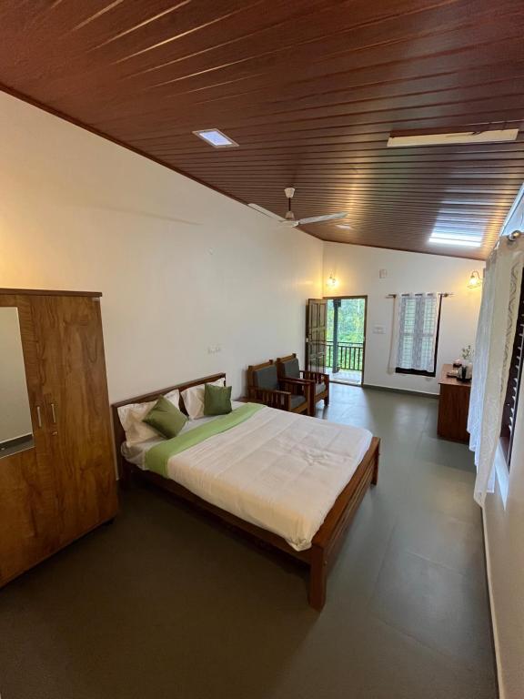 a bedroom with a large bed in a room at THE MASCARA - Home stay @ Coorg in Kushālnagar