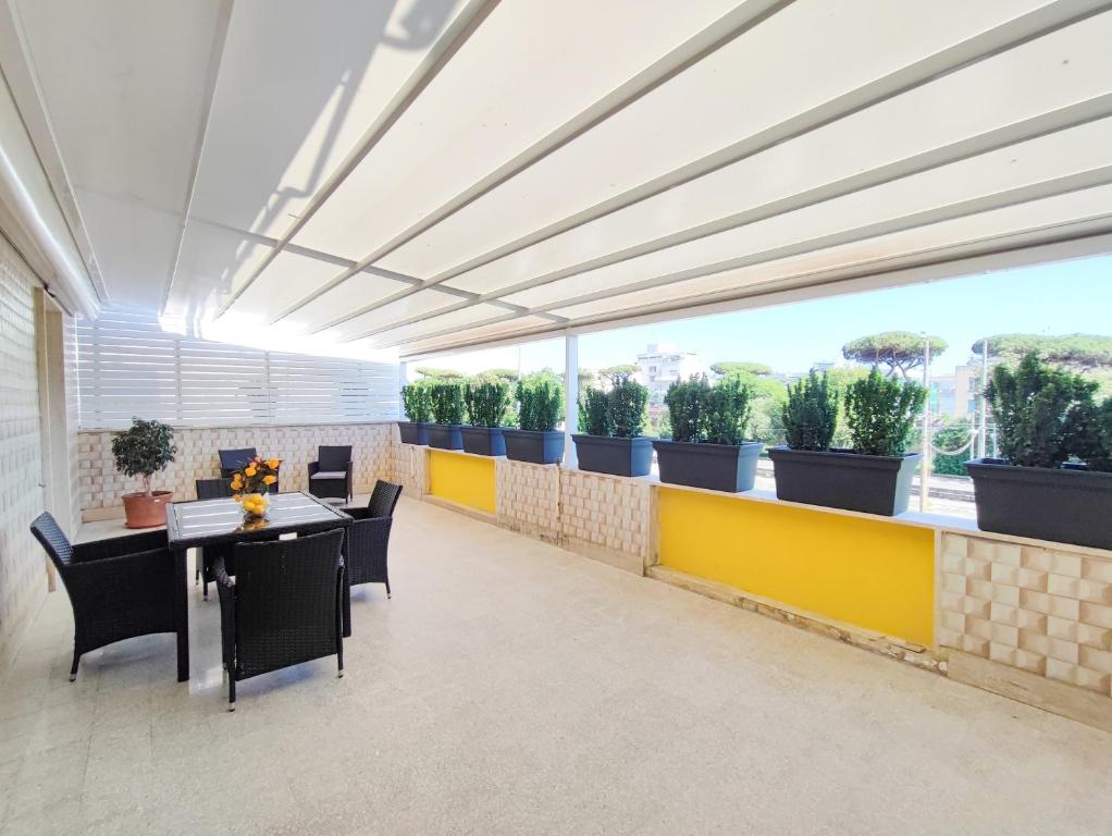 a room with tables and chairs and potted plants at Sole Paola in Anzio