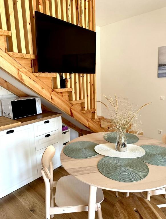 a dining room with a table and a flat screen tv at Rugio namai-Rye house in Palanga
