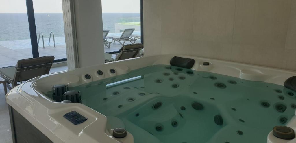 uma banheira num quarto com vista para o oceano em Apartament Anisia Infiniti Resort & Spa em Mamaia Nord – Năvodari