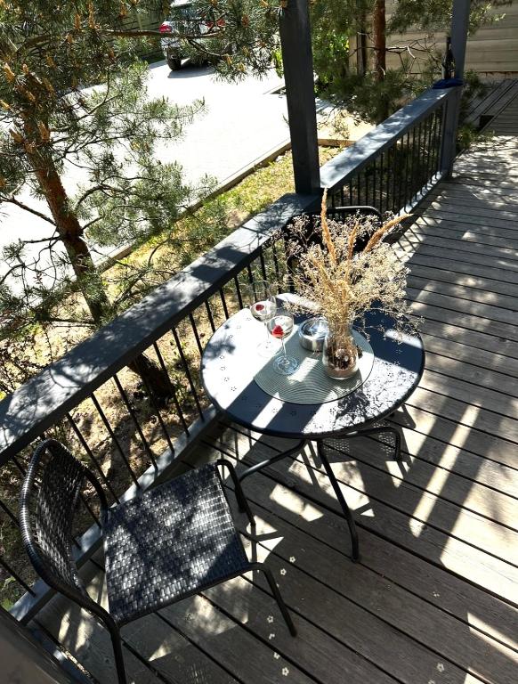a table and chairs on a wooden deck at Rugio namai-Rye house in Palanga