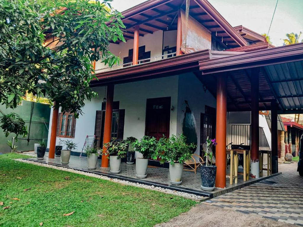 uma casa com vasos de plantas em frente em Serendip Villa Holiday Home Talalla Sri Lanka em Talalla South