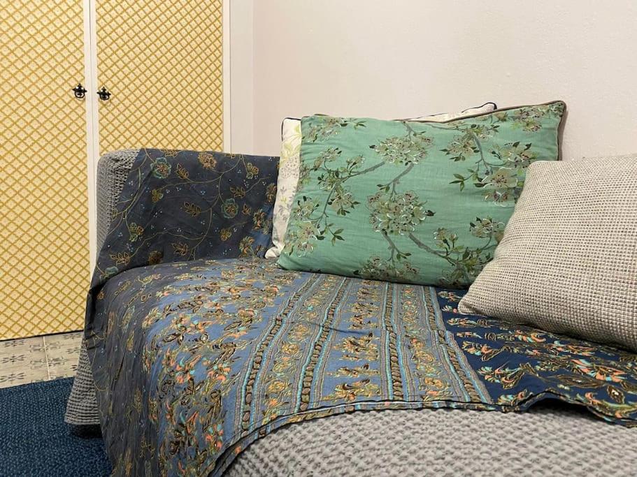 een bed met een deken en een kussen erop bij Iris' Apartment in Thessaloniki