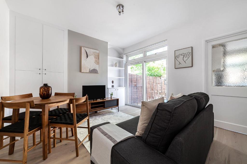 a living room with a couch and a table at The Neasden Villas in London