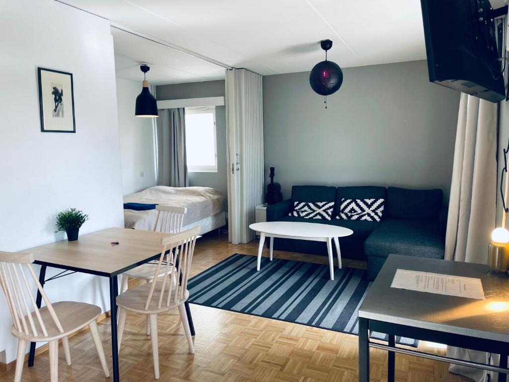 a living room with a couch and a table at Tapiola City Apartment in Espoo
