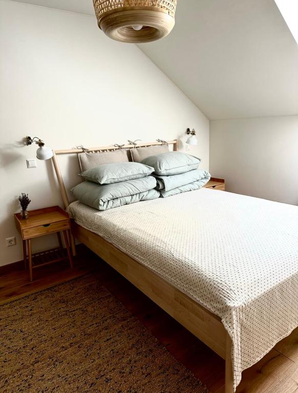 a bedroom with a bed with two pillows on it at Rugio namai-Rye house in Palanga