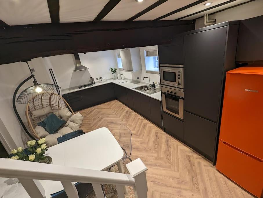 a kitchen with a white table and an orange refrigerator at Zeppelin House - Riverside 18th Century Townhouse in Bewdley