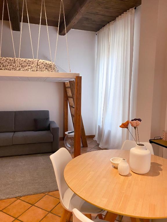 ein Wohnzimmer mit einem Tisch und einem Sofa in der Unterkunft Appartamento in centro storico L&L house in Imola