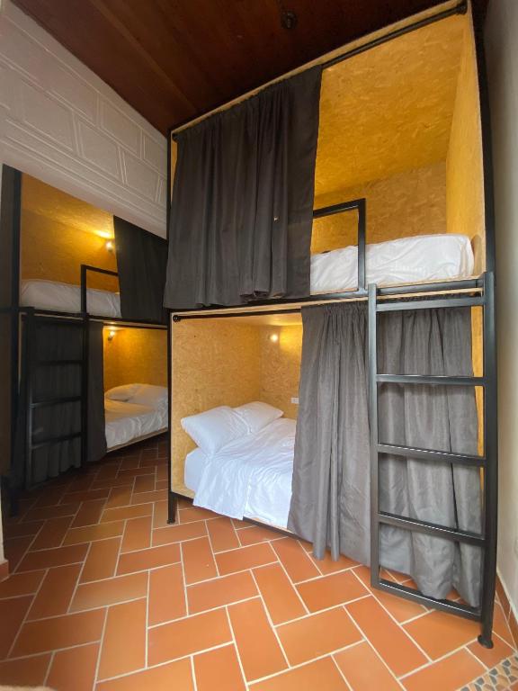 two bunk beds in a room with a floor at banana hostel in Bogotá