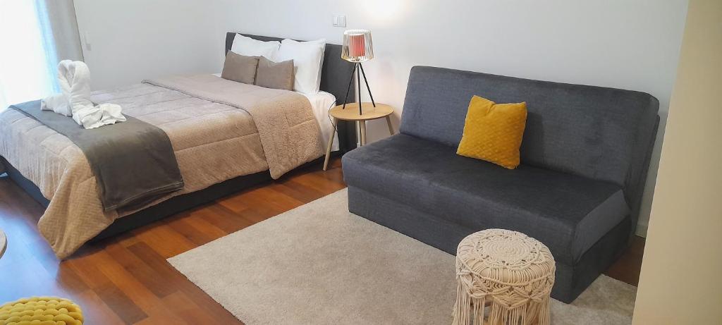 um quarto com uma cama, uma cadeira e uma cama em Ria Palace Apartment em Aveiro