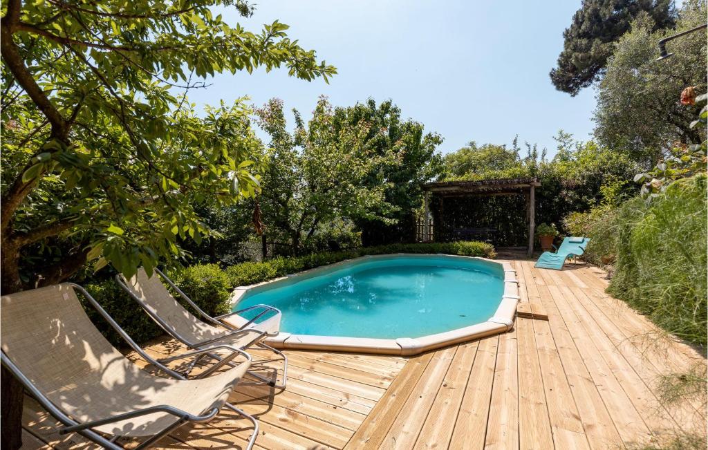 a swimming pool on a wooden deck with two lounge chairs at Cozy Home In Orbicciano With Wifi in Monsagrati