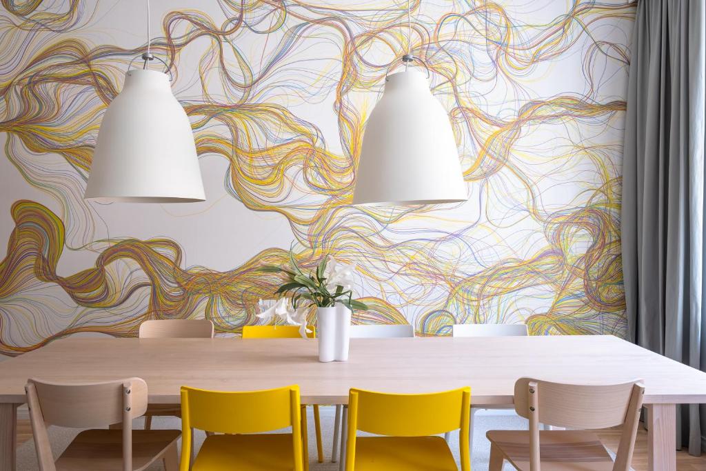 une salle à manger avec une table et des chaises jaunes dans l'établissement Luxury Design Gem in City Center with Sauna and workspace, à Helsinki
