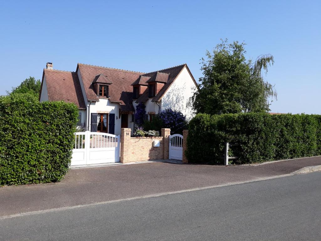 una casa con una puerta blanca y una valla en Thérouanne en Berry, en Plaimpied-Givaudins