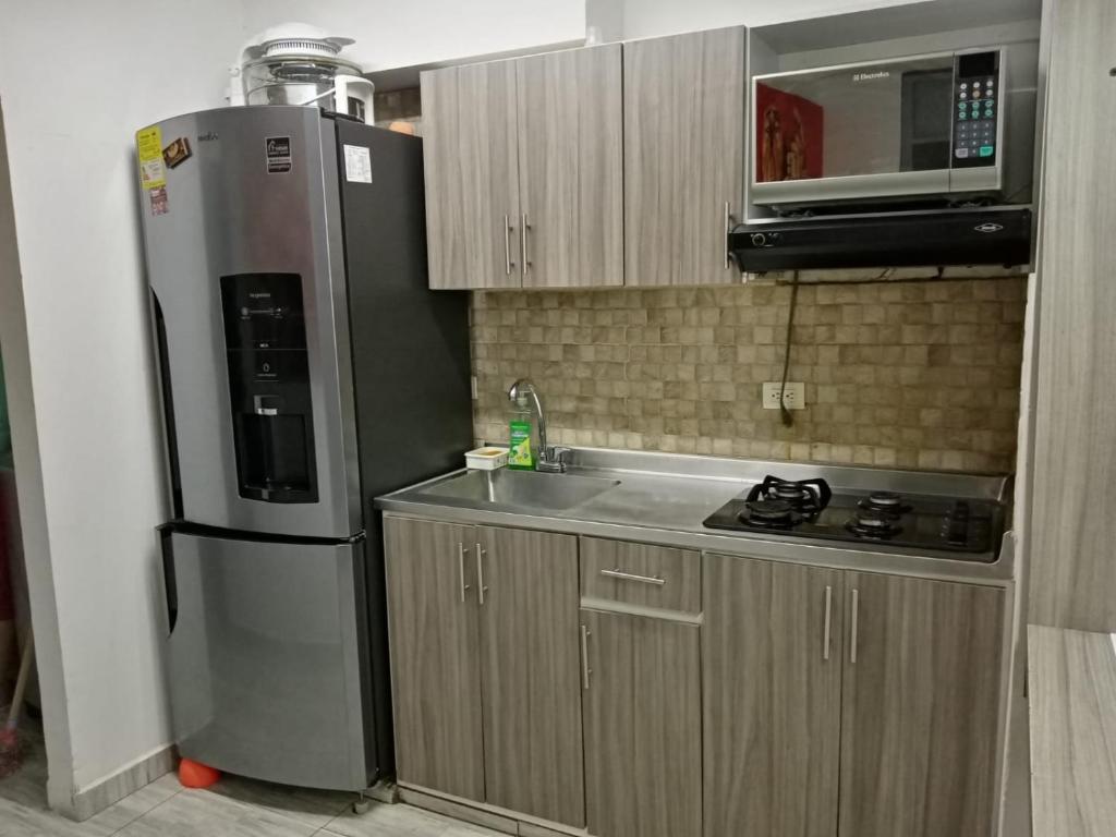 a kitchen with a refrigerator and a sink and a microwave at Apartamento STYLE 2 in San Luis