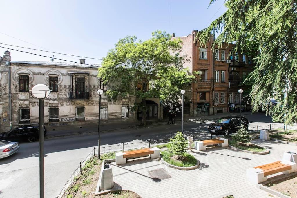 una calle de la ciudad con bancos frente a un edificio en Two bedroom duplex apartment, en Tiflis