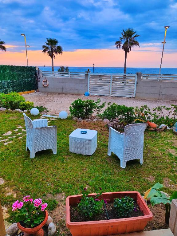 - une terrasse avec des chaises, une table et des fleurs sur la plage dans l'établissement Blue Room, à Termoli
