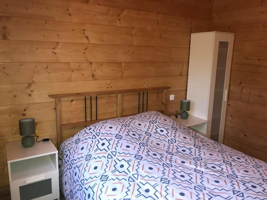 Alièze的住宿－Forest Jura Lodge - Chalet de la Vache，小木屋内一间卧室,配有一张床