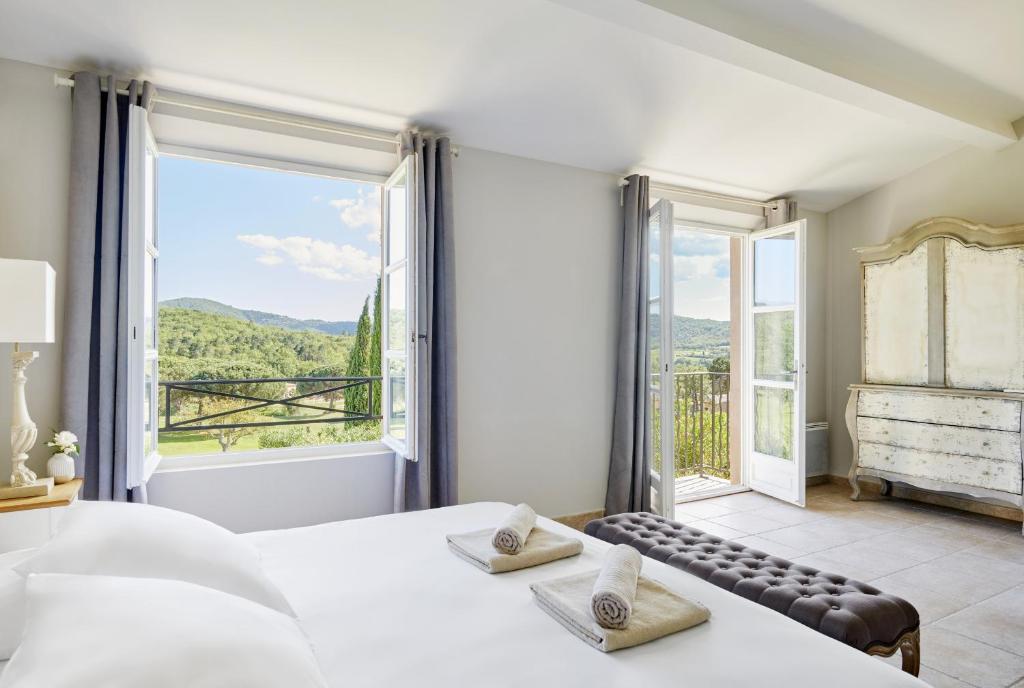 um quarto com uma cama e uma grande janela em Golf Resort & Country Club Saint-Tropez em Saint-Tropez