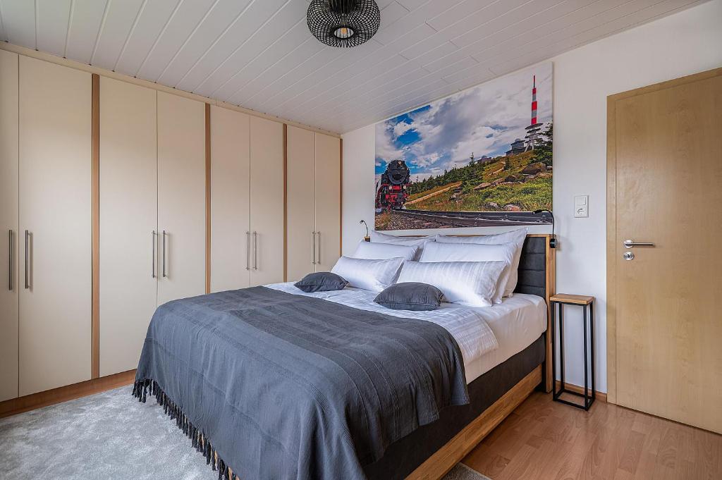 1 dormitorio con 1 cama grande y una pintura en la pared en Neu! Inklusive Bettwäsche, Handtücher und vieles mehr - Perfekt für Urlaub, Familie und Workation - Boxspringbetten und Arbeitsplatz en Bad Harzburg