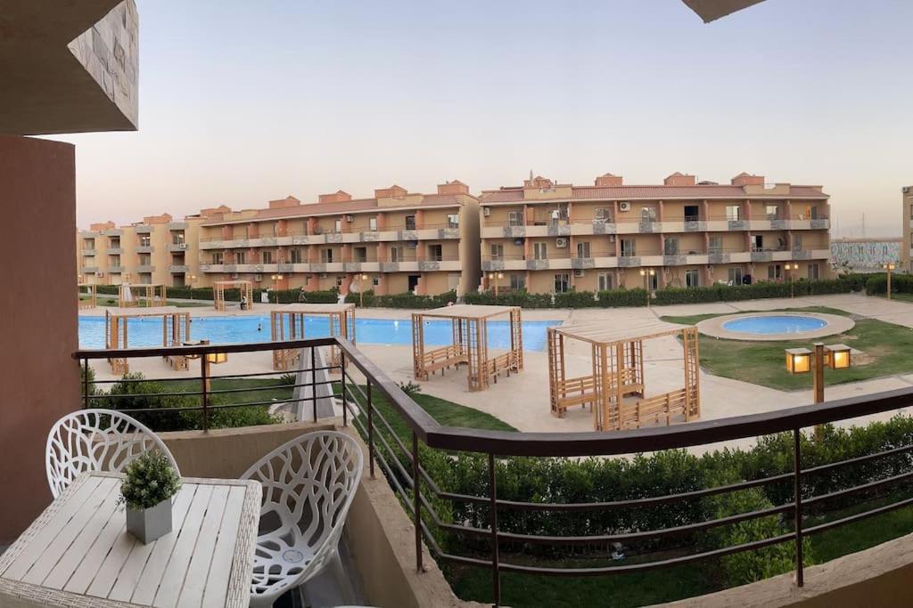 un hotel con piscina, mesas y un edificio en Sun Mirror Chalet El Sokhna, en Ain Sokhna