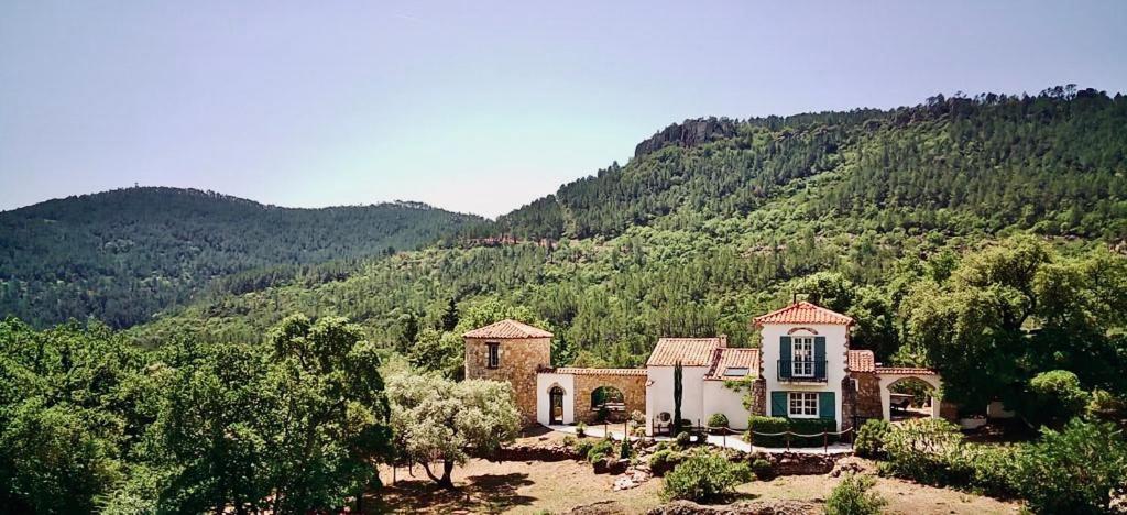 une grande maison au milieu d'une montagne dans l'établissement L’Hacienda Maison d’hôtes, à Bagnols-en-Forêt