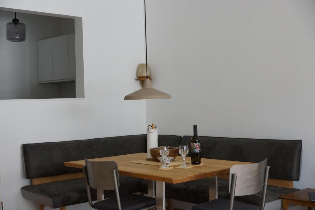 een eettafel met wijnflessen en stoelen bij Haus Bergkristall - Apartment Schneider in Seefeld in Tirol