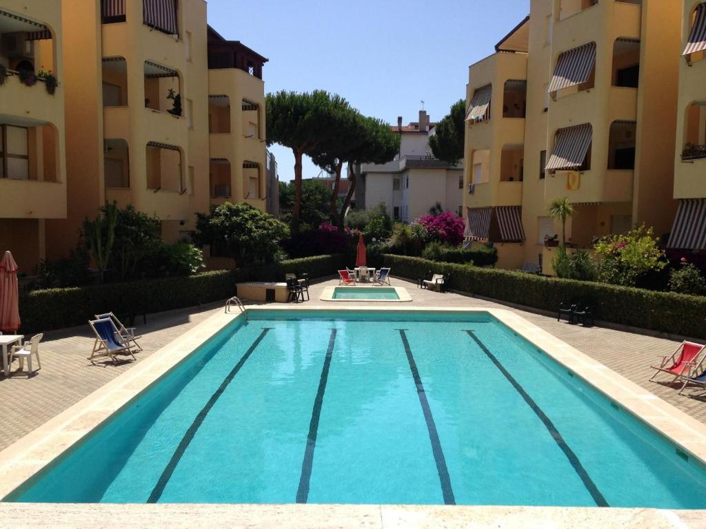 a swimming pool in front of two apartment buildings at Da Ike residence con piscina in Santa Marinella