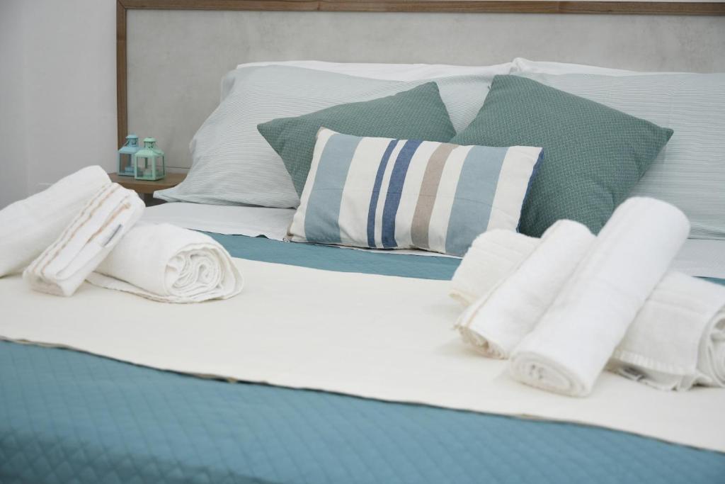 Una cama con toallas y almohadas. en Jolie Maison, en Brindisi