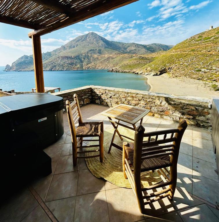 a patio with a table and chairs and a view of the ocean at Marmari Paradise Resort Hotel in Marmari