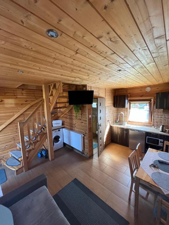 a kitchen and living room in a log cabin at Domki Teo Piętrowe I Parterowe in Rewal