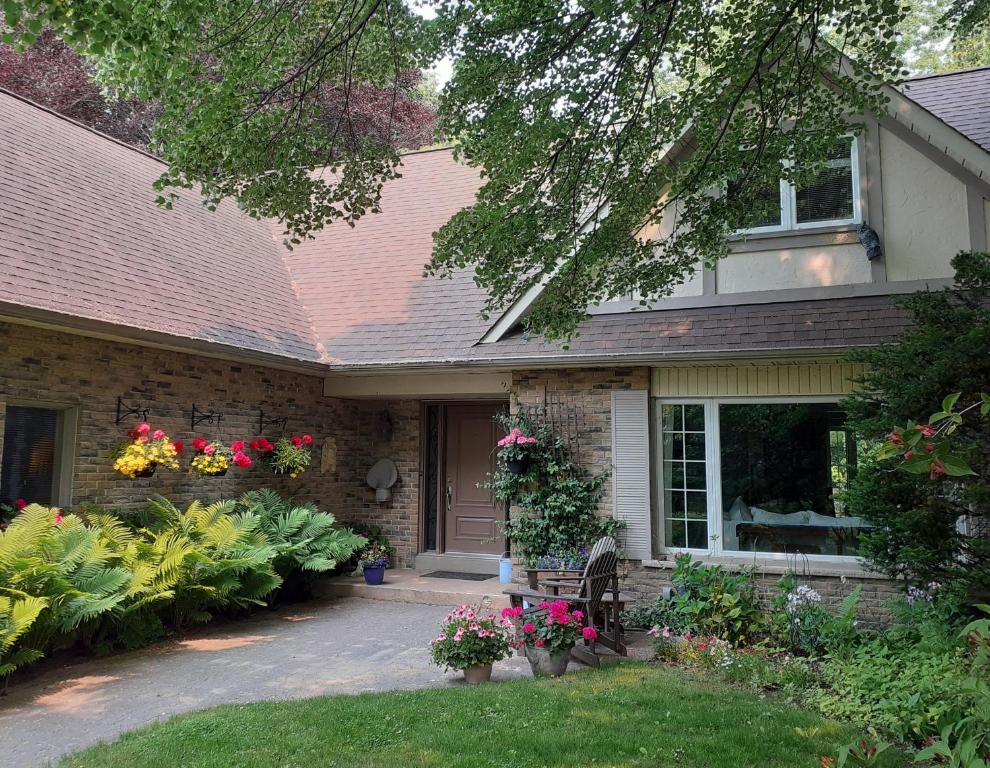 una casa con flores en el patio delantero en Greater Toronto B&B, en Oakville