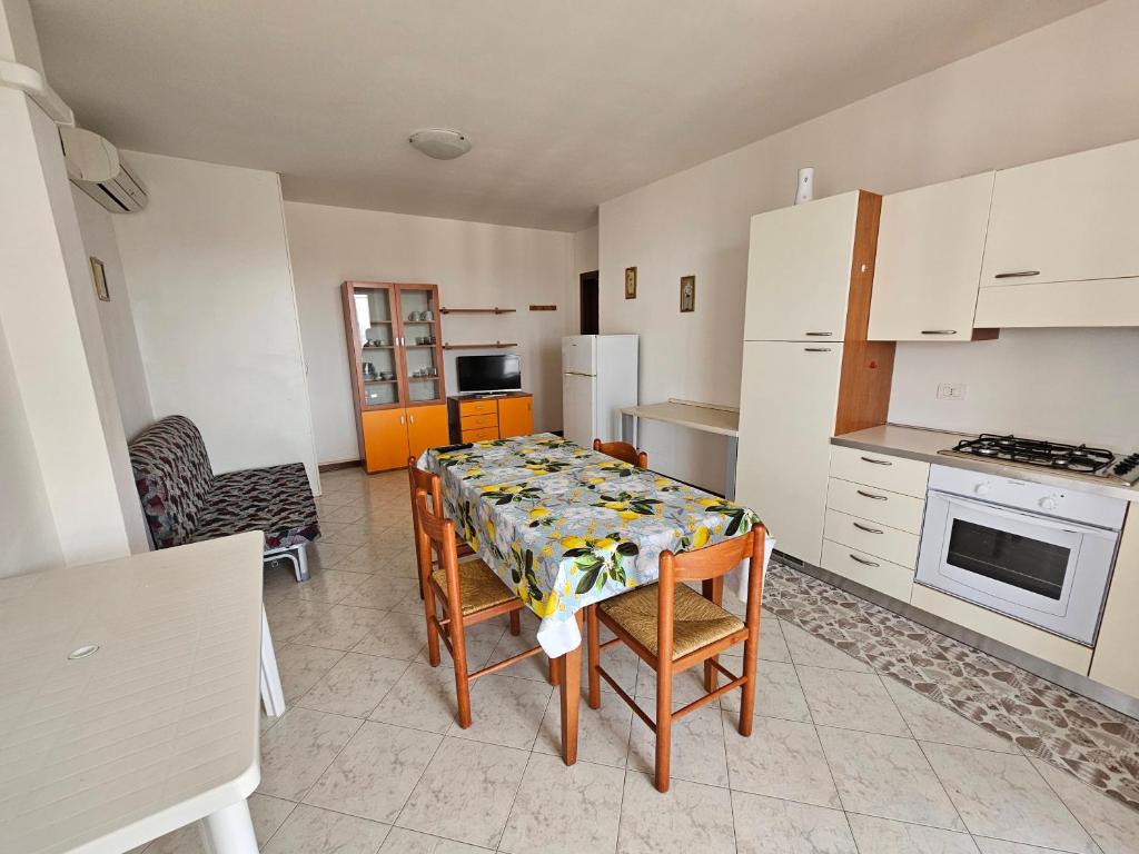 a kitchen with a table and chairs and a kitchen with white appliances at Appartamento a Porto Garibaldi vicino al mare in Porto Garibaldi