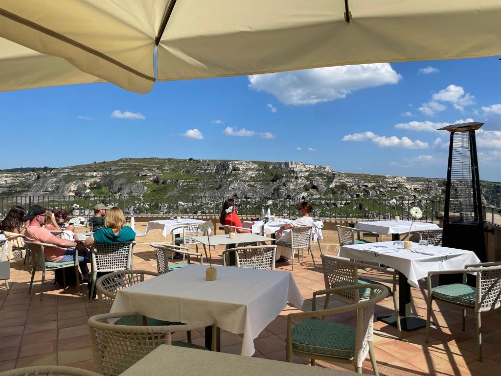 um restaurante com mesas e cadeiras com vista para a cidade em Quarry Resort em Matera