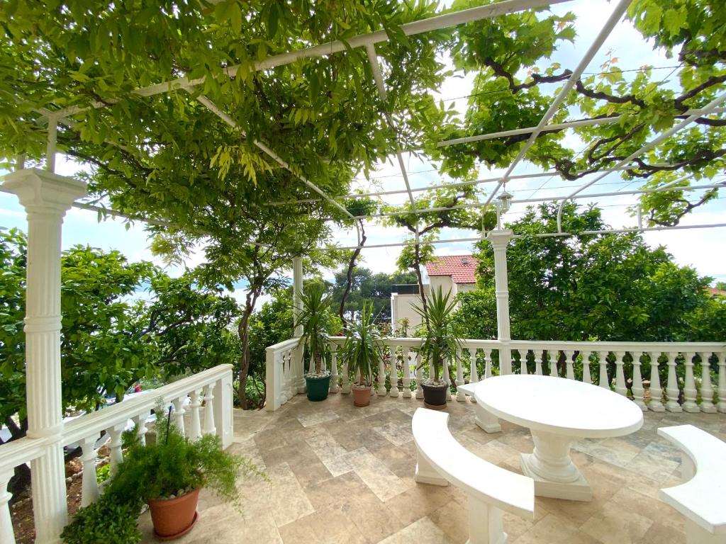 a patio with a white table and potted plants at Apartments and Rooms Katarina in Živogošće