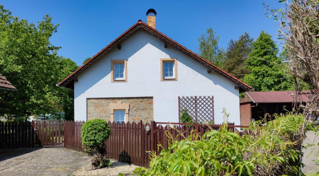 a white house with a wooden fence at Apartmán na Koskách in Třeboň