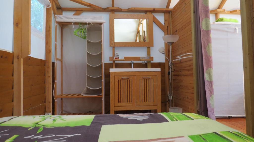 1 dormitorio con cama, lavabo y espejo en Lodge de Travo, en Ventiseri
