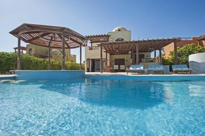a large swimming pool in front of a house at شاليه دوبلكس فالجونه للايجار in Hurghada