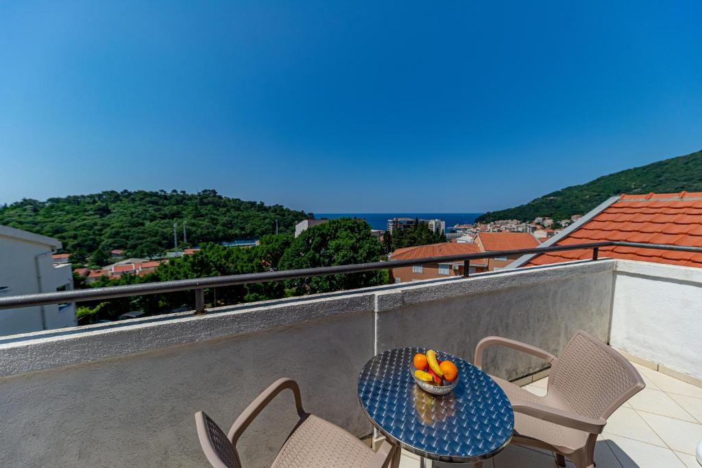 uma mesa e cadeiras numa varanda com uma taça de fruta em Apartment Knezevic em Petrovac na Moru