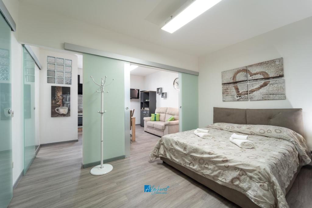 Un dormitorio con una cama y una sala de estar. en City Center white, en Alghero